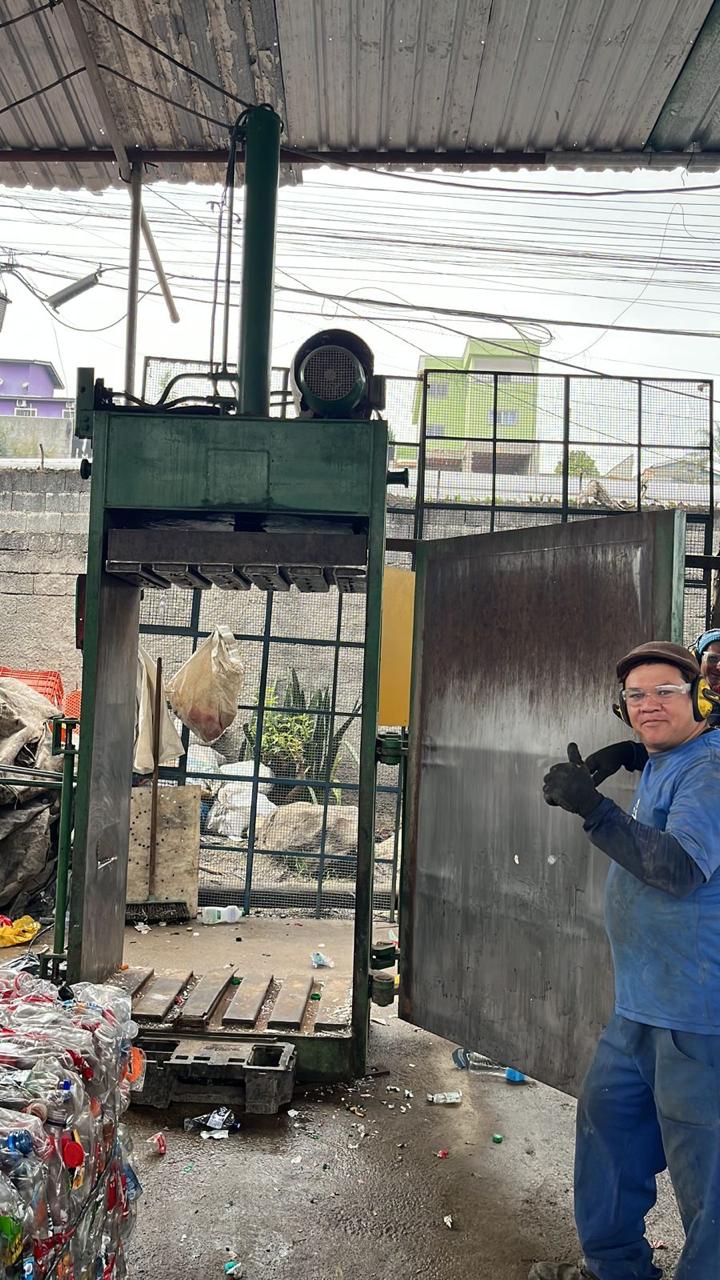 Colaborador da STR ao lado da prensa de reciclagem